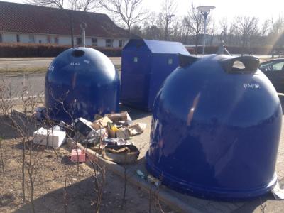 Tre blå container med affald kastet på jorden