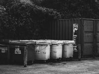 Fem skraldespande og en container (sort/hvid foto)